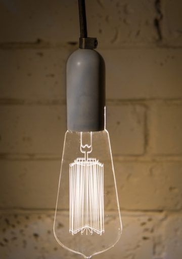 Una Lámpara con Base de Hormigón con la Bombilla como Protagonista